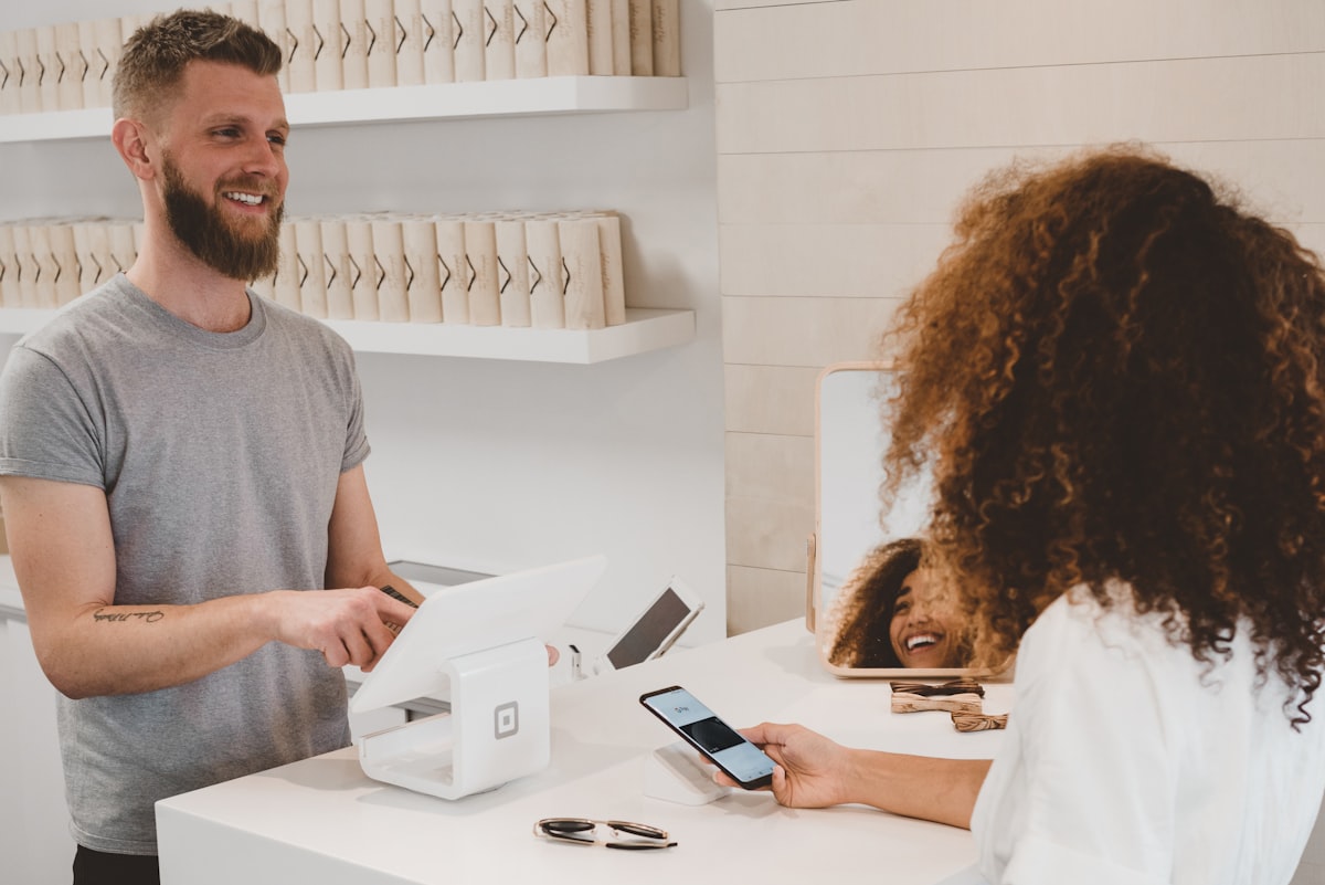 Agente conclude una vendita con tablet e pagamento da smartphone al banco