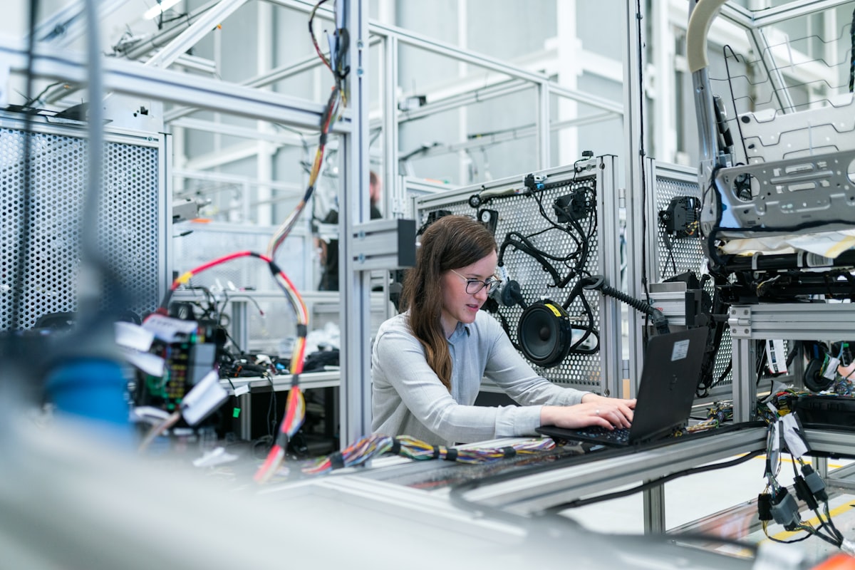 Tecnica al lavoro su una postazione industriale con laptop