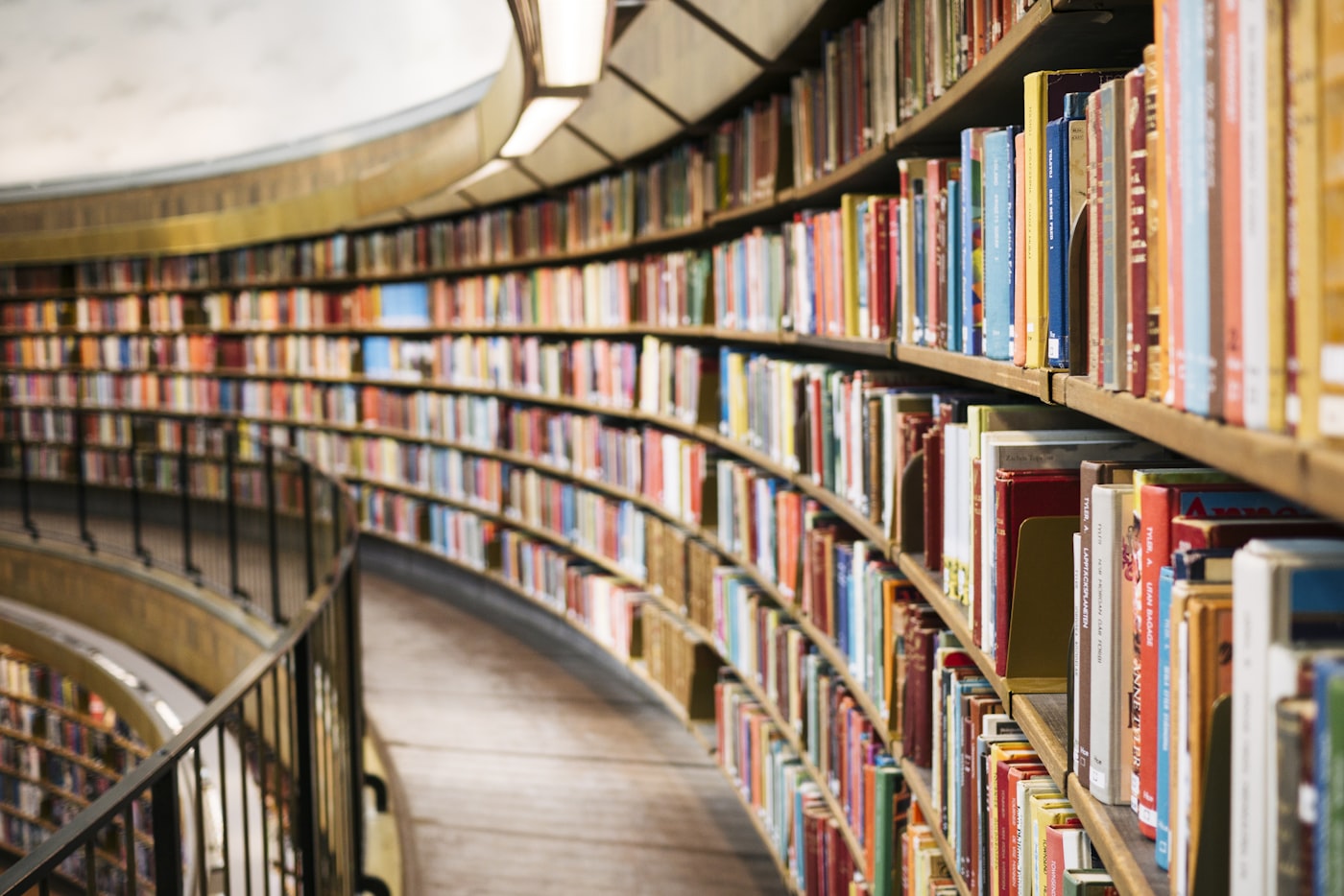 Scaffali curvi di una biblioteca pieni di libri colorati